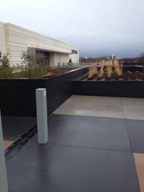 Norstone Lynia Interlocking Tiles in Ebony Basalt color used to clad the landscape walls surrounding the entrance to a mall
